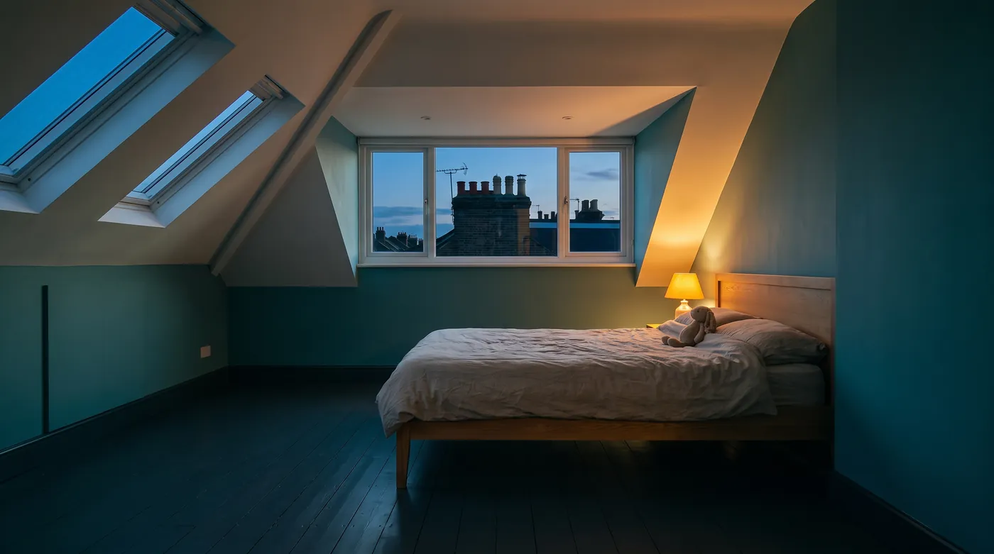 Illustrative image: a converted loft room with a dormer window and a low kneewall.